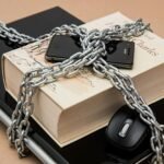 Chain-locked book, phone, and laptop symbolizing digital and intellectual security.