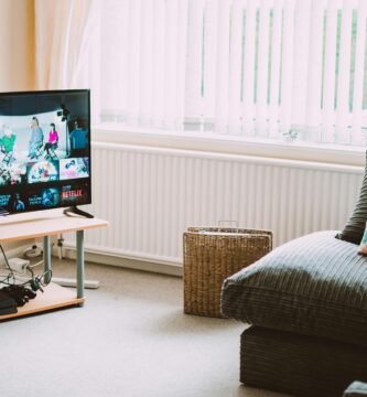 Chic and comfortable living room featuring a modern sofa, decorative pillows, and a TV streaming popular shows.