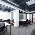 Spacious and modern office interior with sleek furniture and bright lighting.