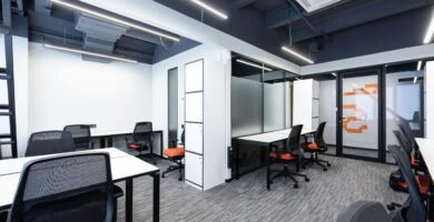 Spacious and modern office interior with sleek furniture and bright lighting.